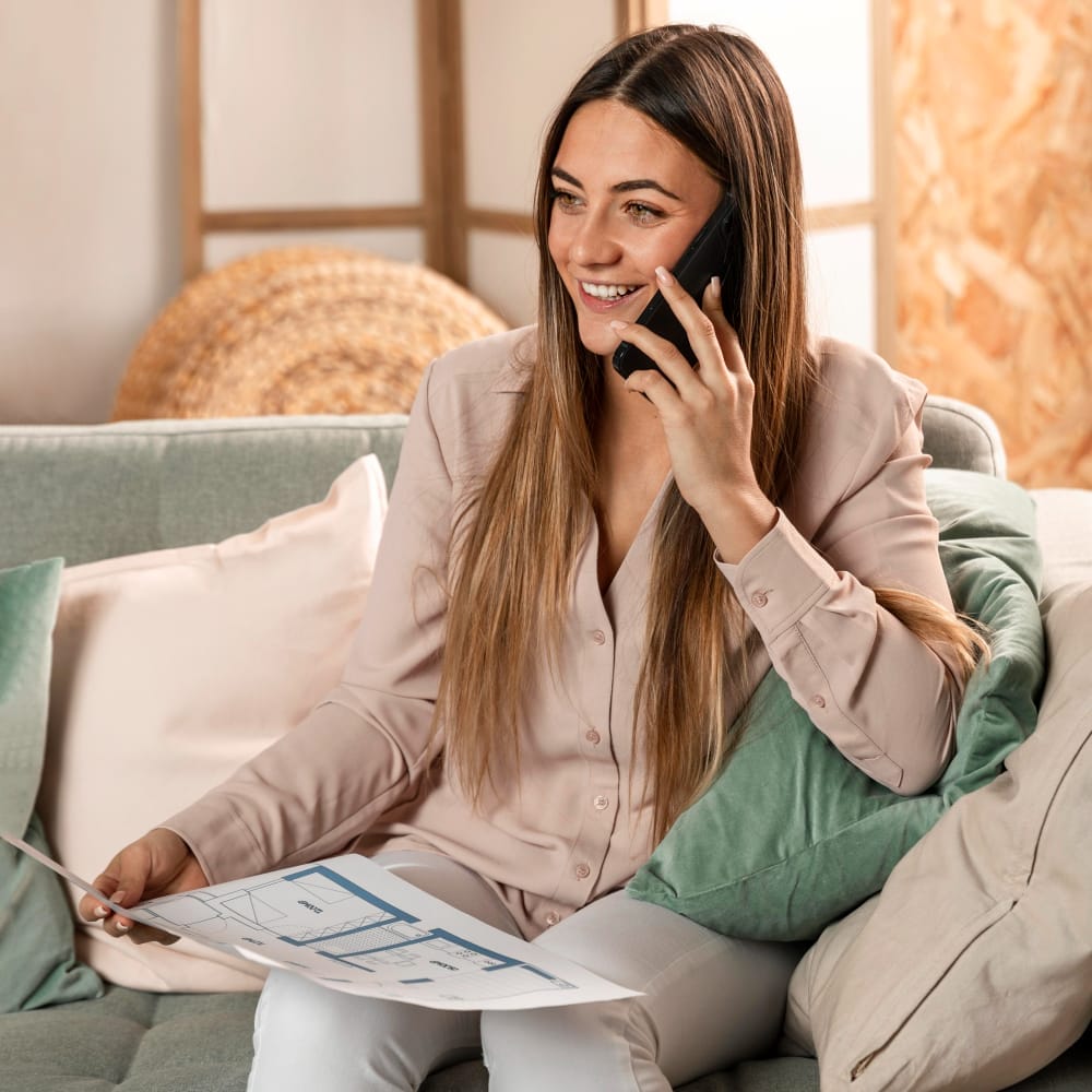 Smiling Caucasian woman holding a floorplan having a great customer experience interacting with an agent.