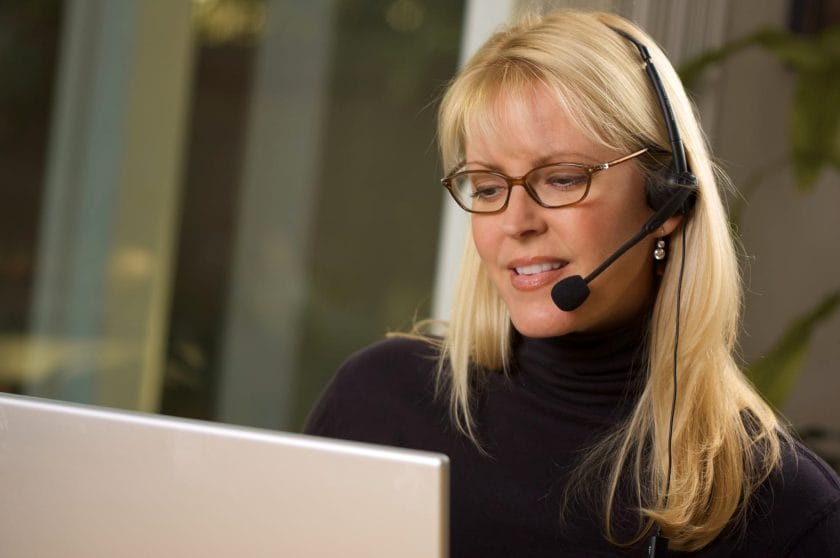 Caucasian female telemarketer making a sales call to a potential client.
